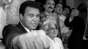 A smiling Muhammad Ali shows his fist to reporters during an impromptu news conference in Mexico City in this July 9, 1987 file photo. REUTERS/Jorge Nunez/File Photo